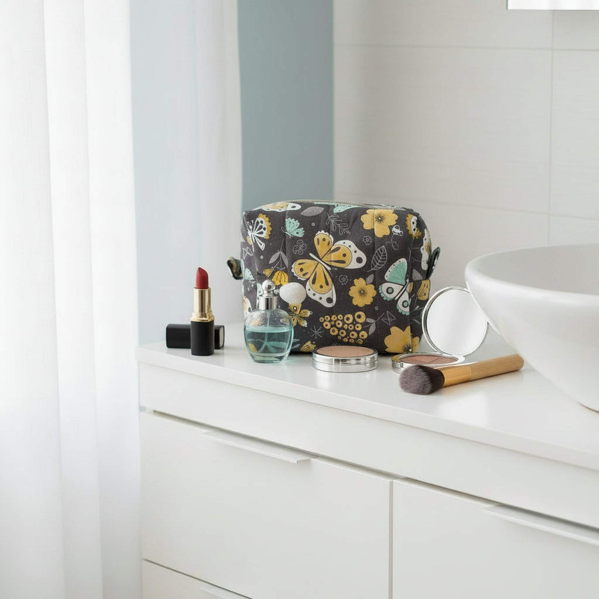 Yellow butterfly cosmetic pouch on bathroom vanity with makeup