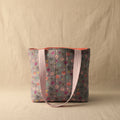 Front view of gray hand-quilted floral tote with pink handles