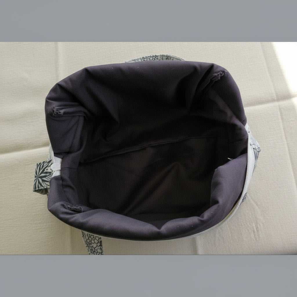 Open view of quilted cosmetic bag showing gray interior lining