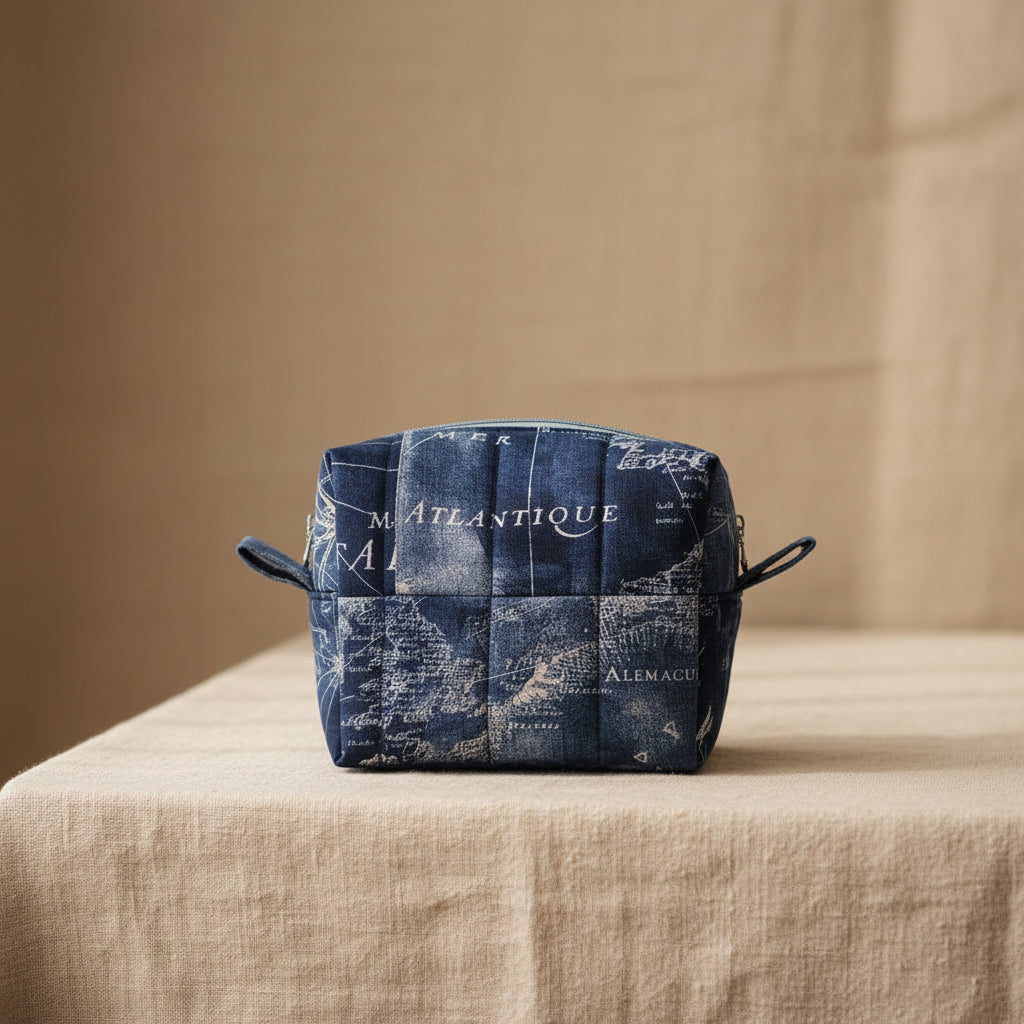 Navy blue quilted mini cosmetic bag with vintage world map print and zip closure