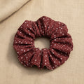 Flat lay of red fabric scrunchie with white stars