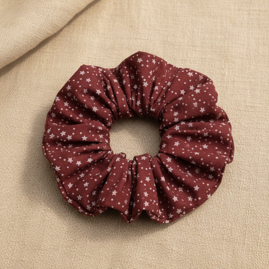 Flat lay of red fabric scrunchie with white stars