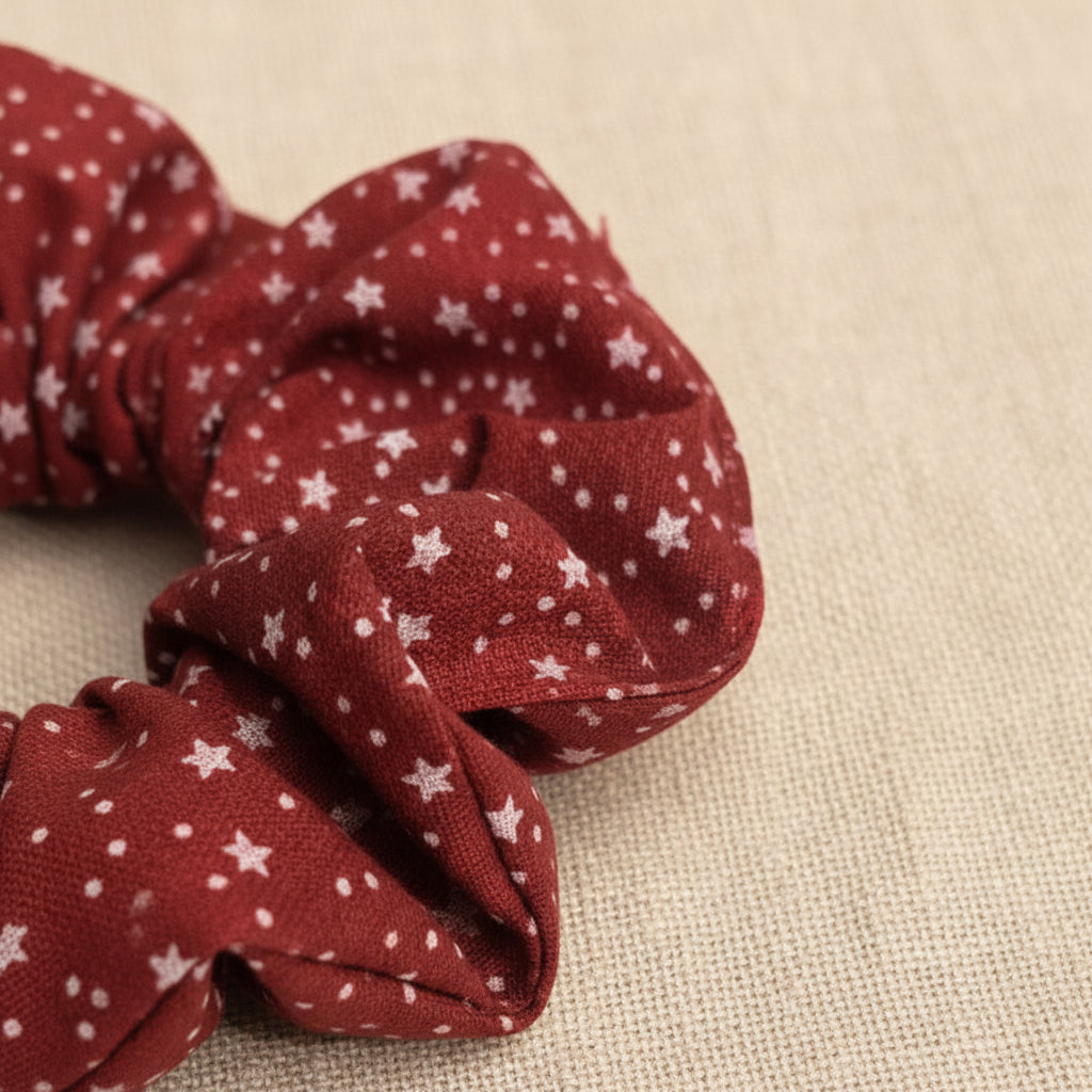 Red cotton scrunchie with white swirling stars close-up