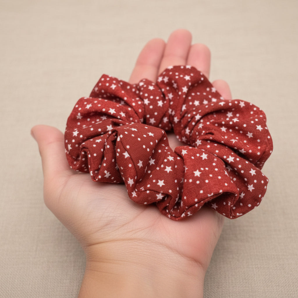 Handmade red star-patterned scrunchie held in hand
