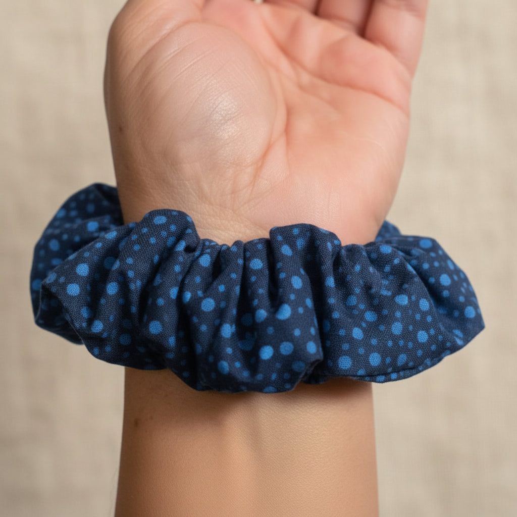 Navy speckled dot scrunchie worn as a wrist bracelet