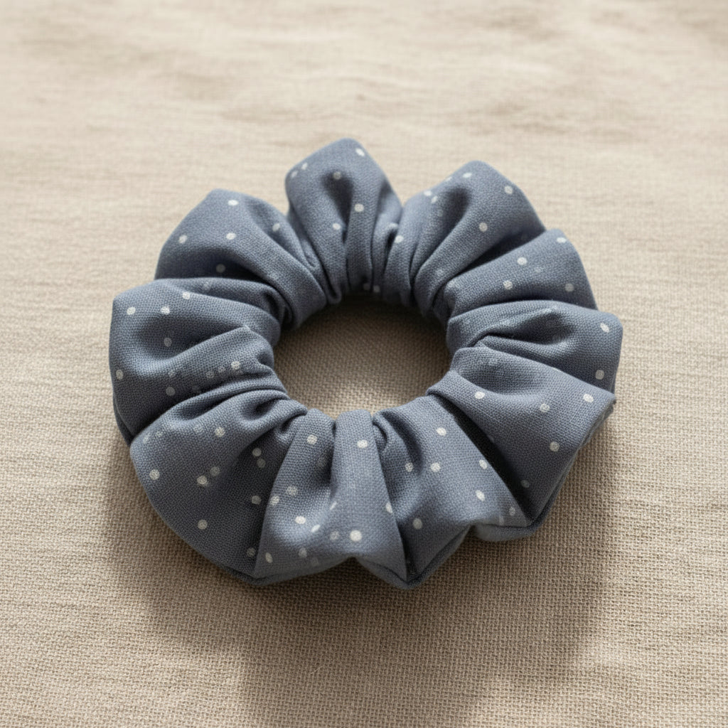 Flat lay of handmade dusty blue polka dot scrunchie