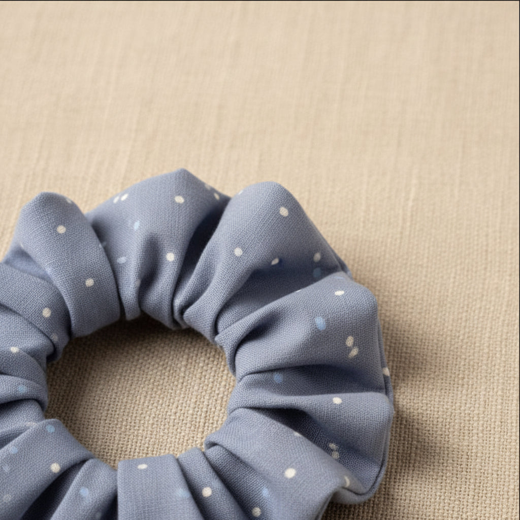 Close-up of dusty blue dotted cotton hair tie texture