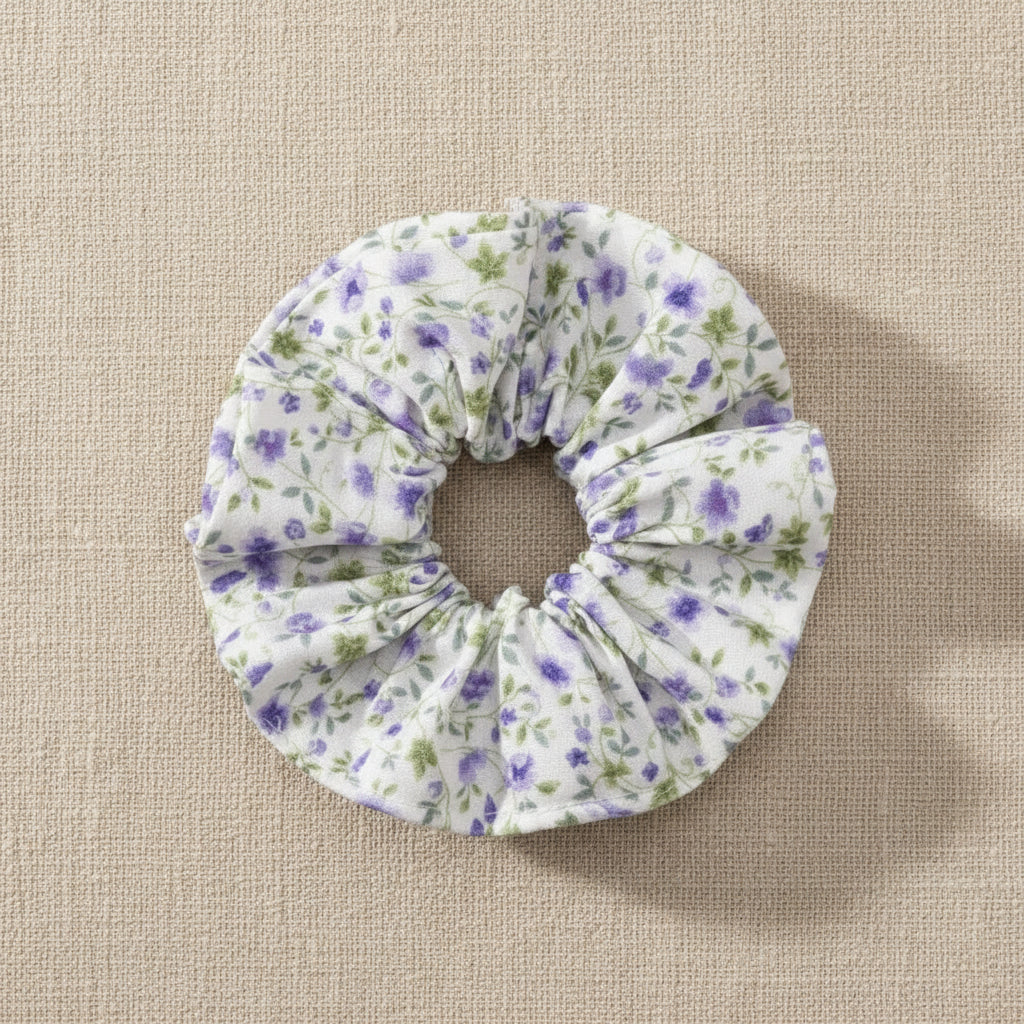 Flat lay of homemade white with tiny lilac flowers scrunchie