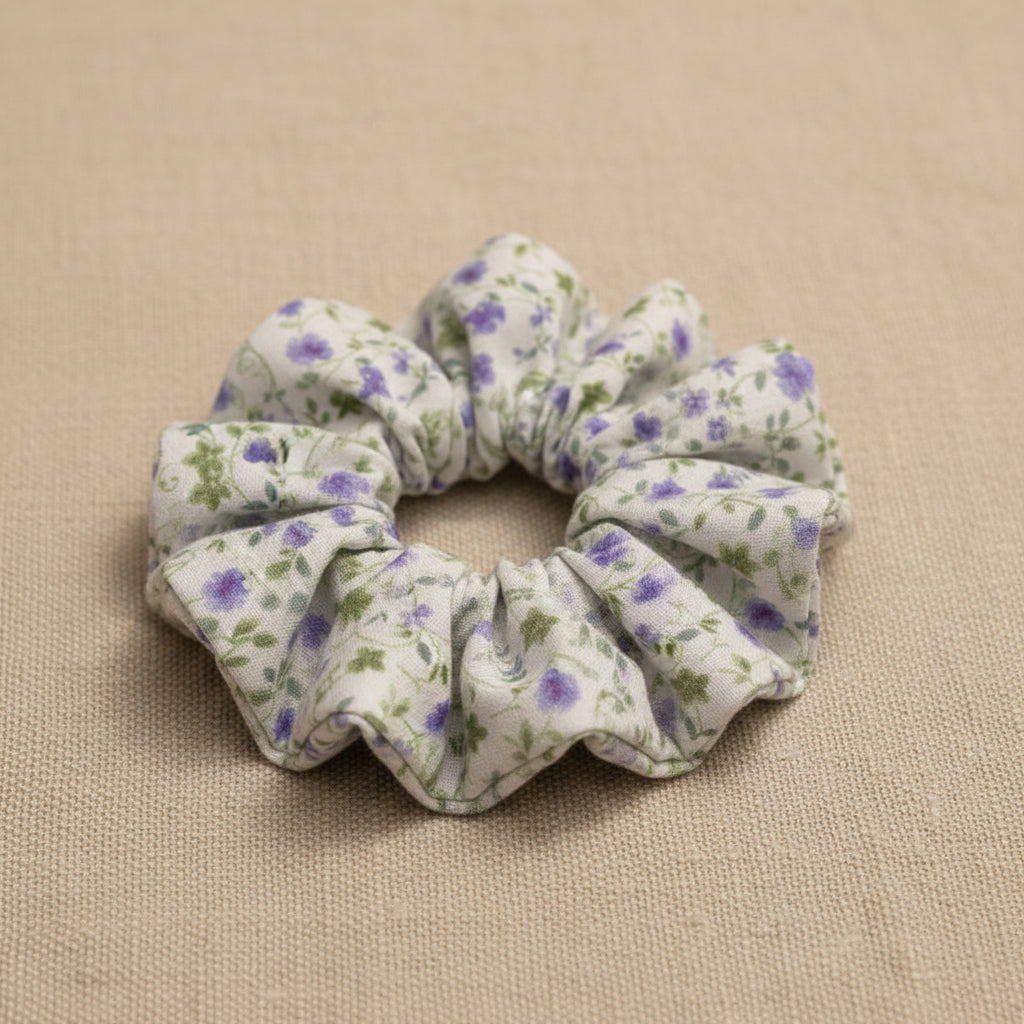 Flat lay of homemade white with tiny lilac flowers scrunchie