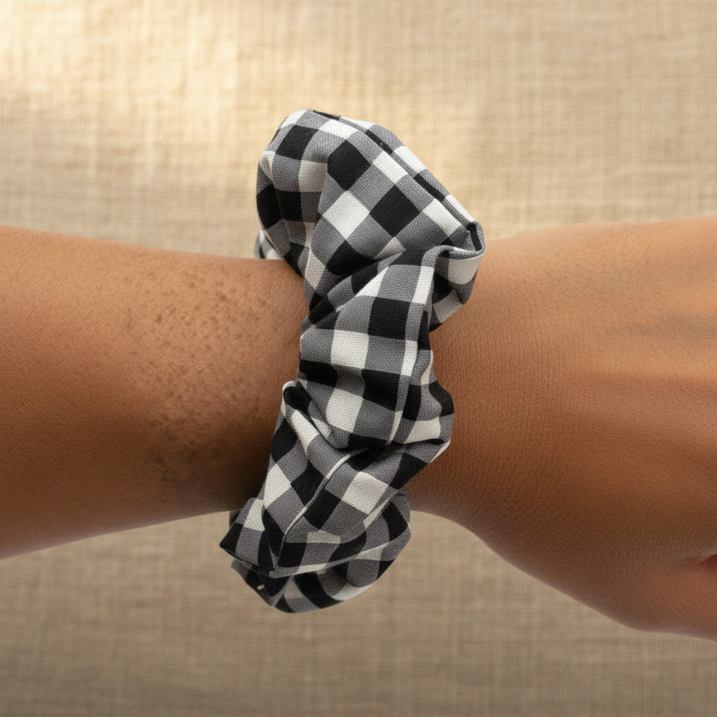 Woman wearing black gingham scrunchie as wrist bracelet