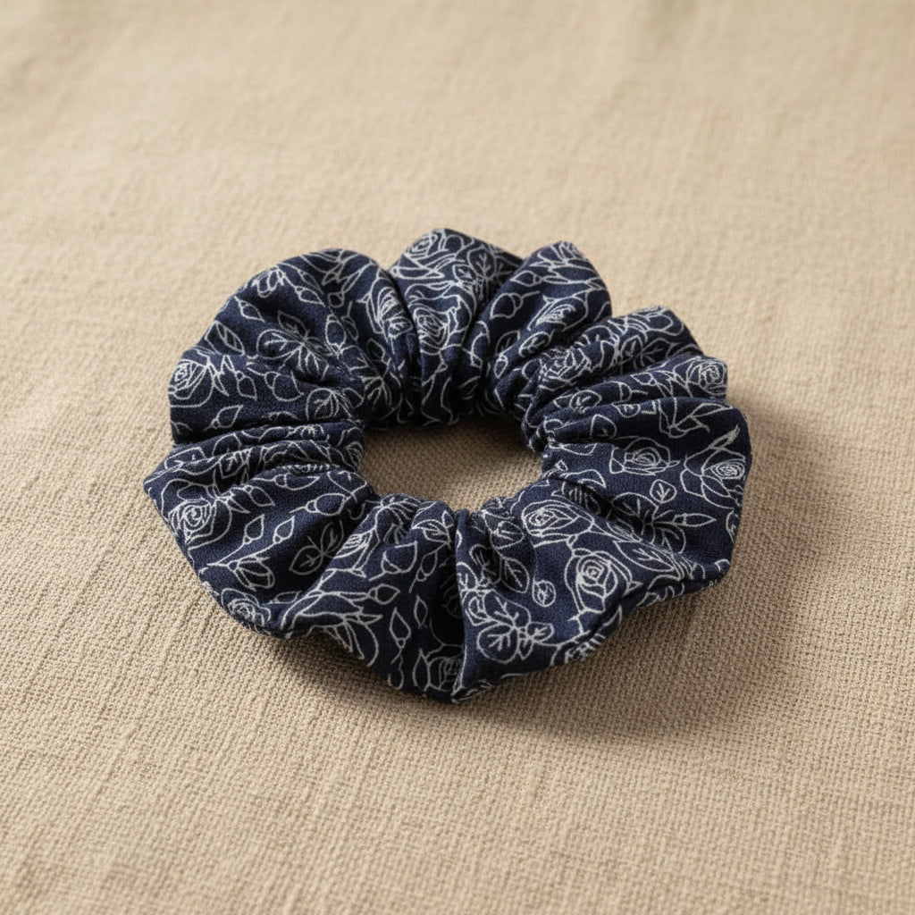 Close-up of gathered navy blue floral hair scrunchie