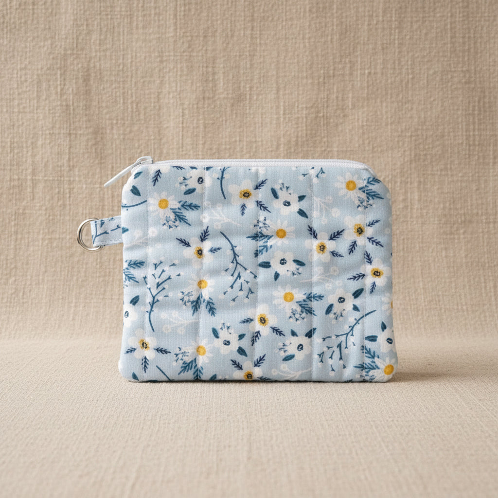 Front view of light blue daisy print hand quilted pouch