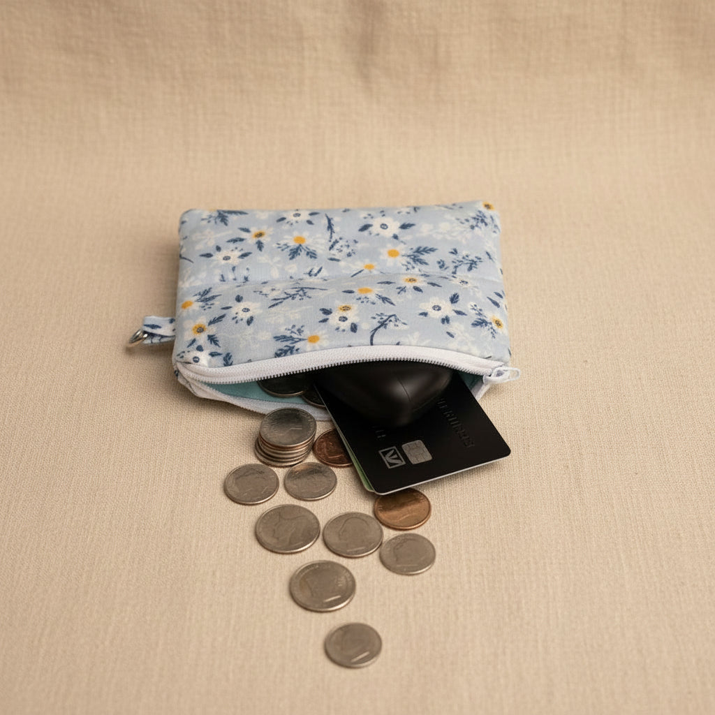 Mini Daisy Hand Quilted Pouch holding coins and earbuds