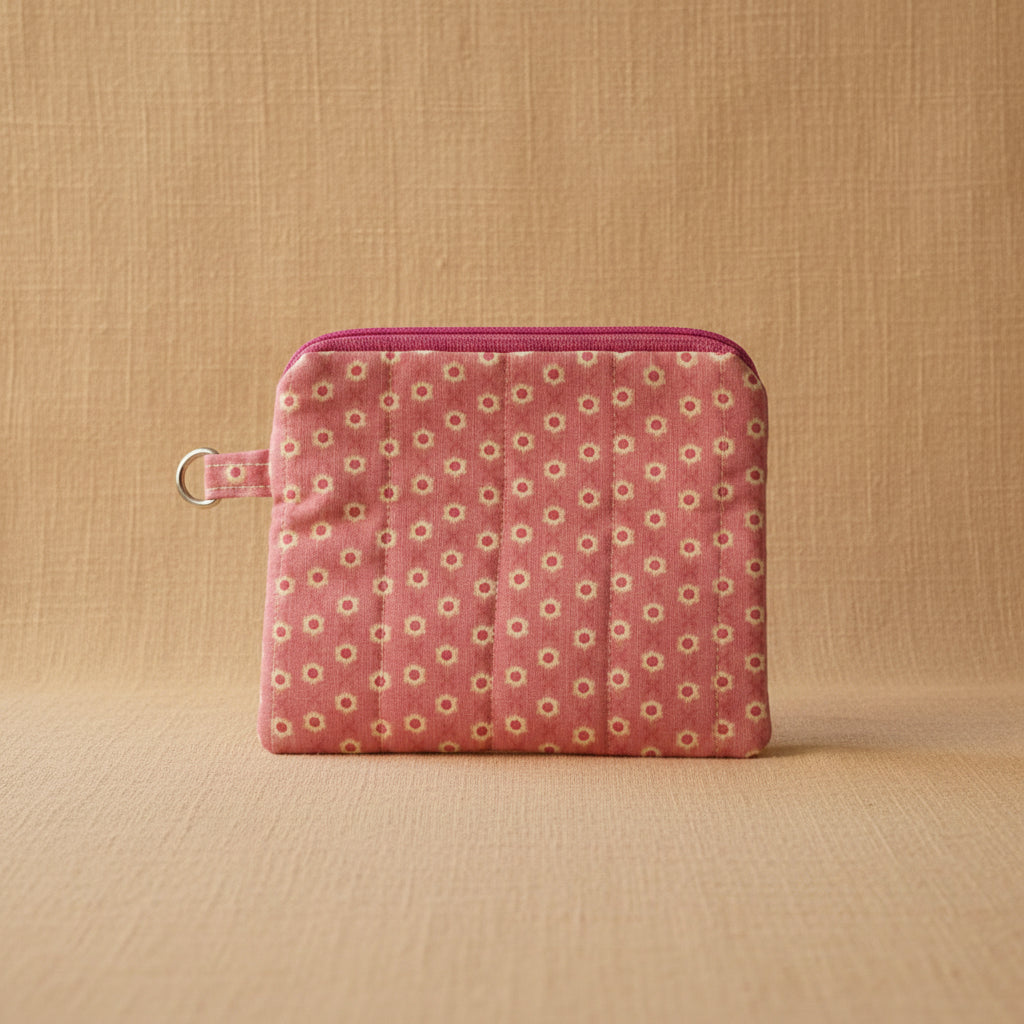 Front view of handmade pink polka dot quilted pouch with zipper and key ring