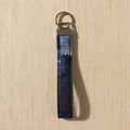 Navy denim wristlet strap with brushed metal bar and split ring