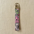 Bold pink floral wristlet strap with antique brass hardware