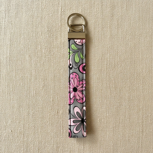 Bold pink floral wristlet strap with antique brass hardware