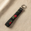 Black cotton wristlet strap with red rose print and silver D-ring