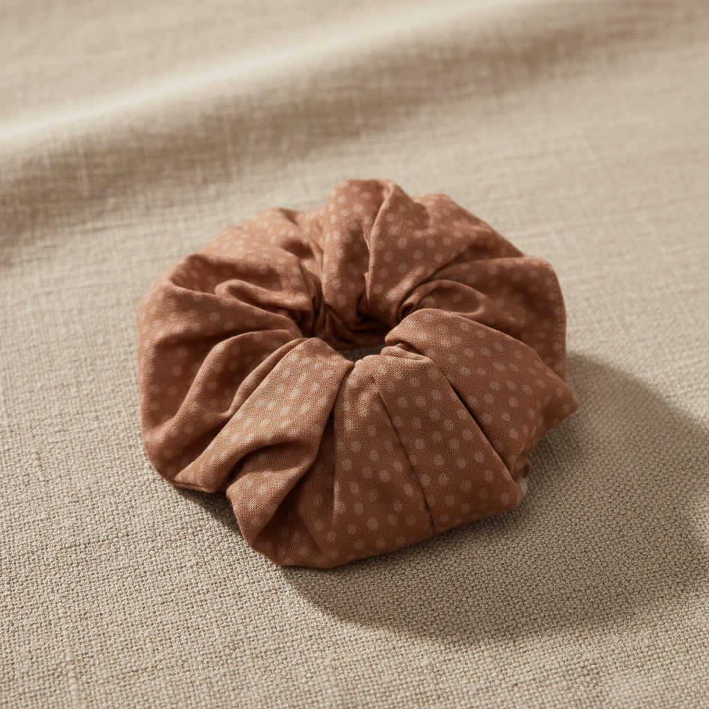 Speckled dusty rose handmade scrunchie close-up on linen