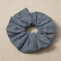 Top-down view of gathered dusty blue scrunchie with uniform ruching