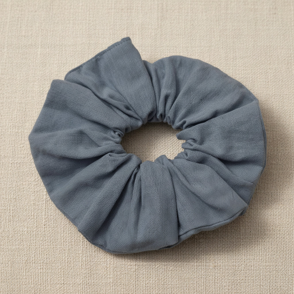 Top-down view of gathered dusty blue scrunchie with uniform ruching