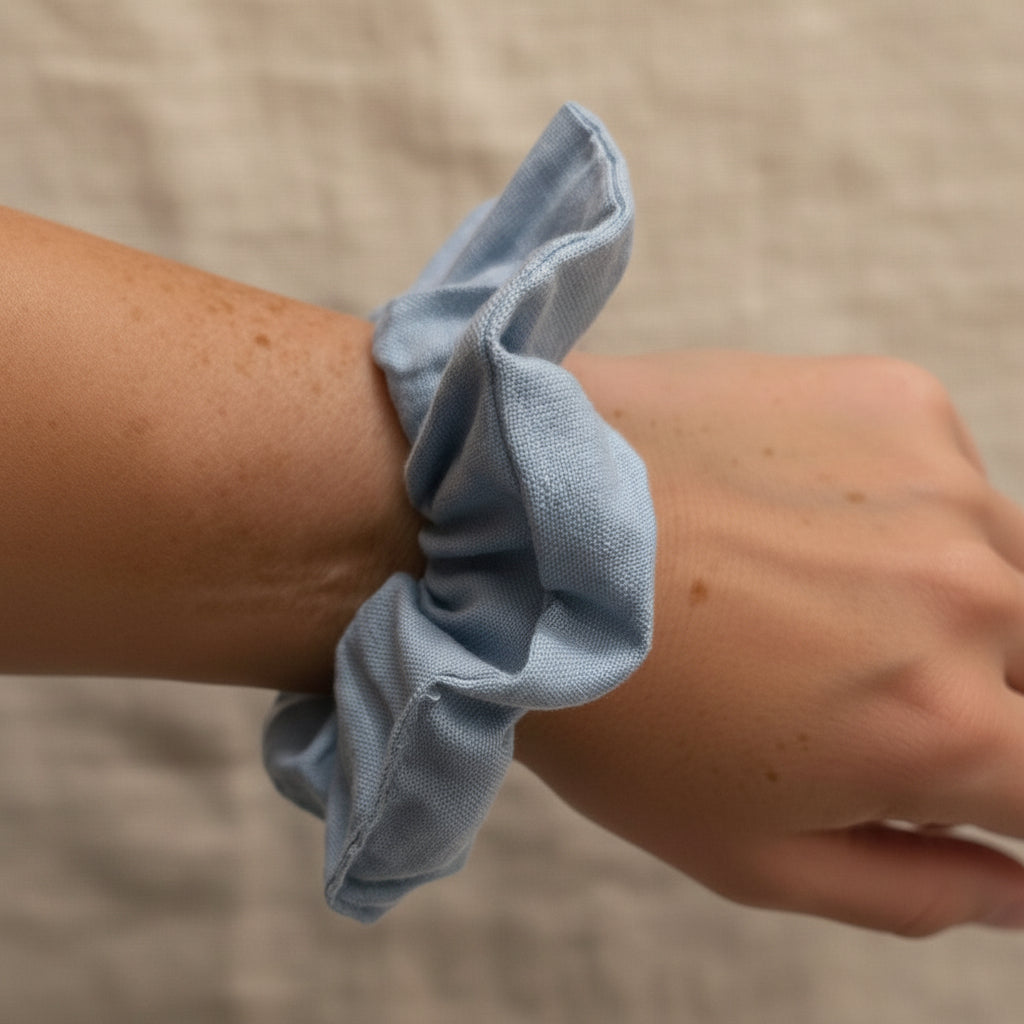 Dusty blue handmade scrunchie on wrist showing soft linen texture