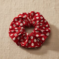 Flat lay of red polka dot hair scrunchie with visible stitching details