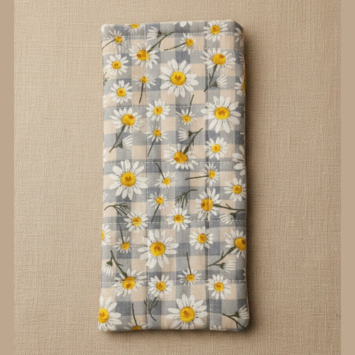 A rectangular fabric item, likely a pouch or sleeve, featuring a daisy and plaid pattern in gray, white, and yellow, photographed against a plain beige background.